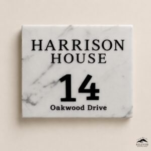 Targa quadrata in marmo bianco venato di grigio con scritte nere in rilievo: Harrison House, numero 14 e Oakwood Drive