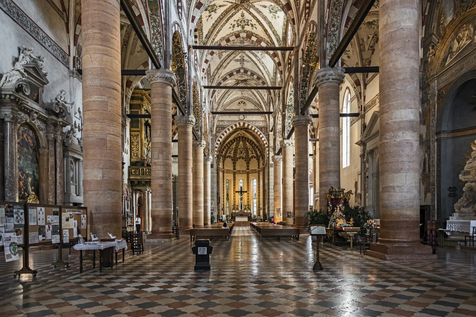 Navata di una chiesa con colonne e pavimenti in pietra rossa veronese
